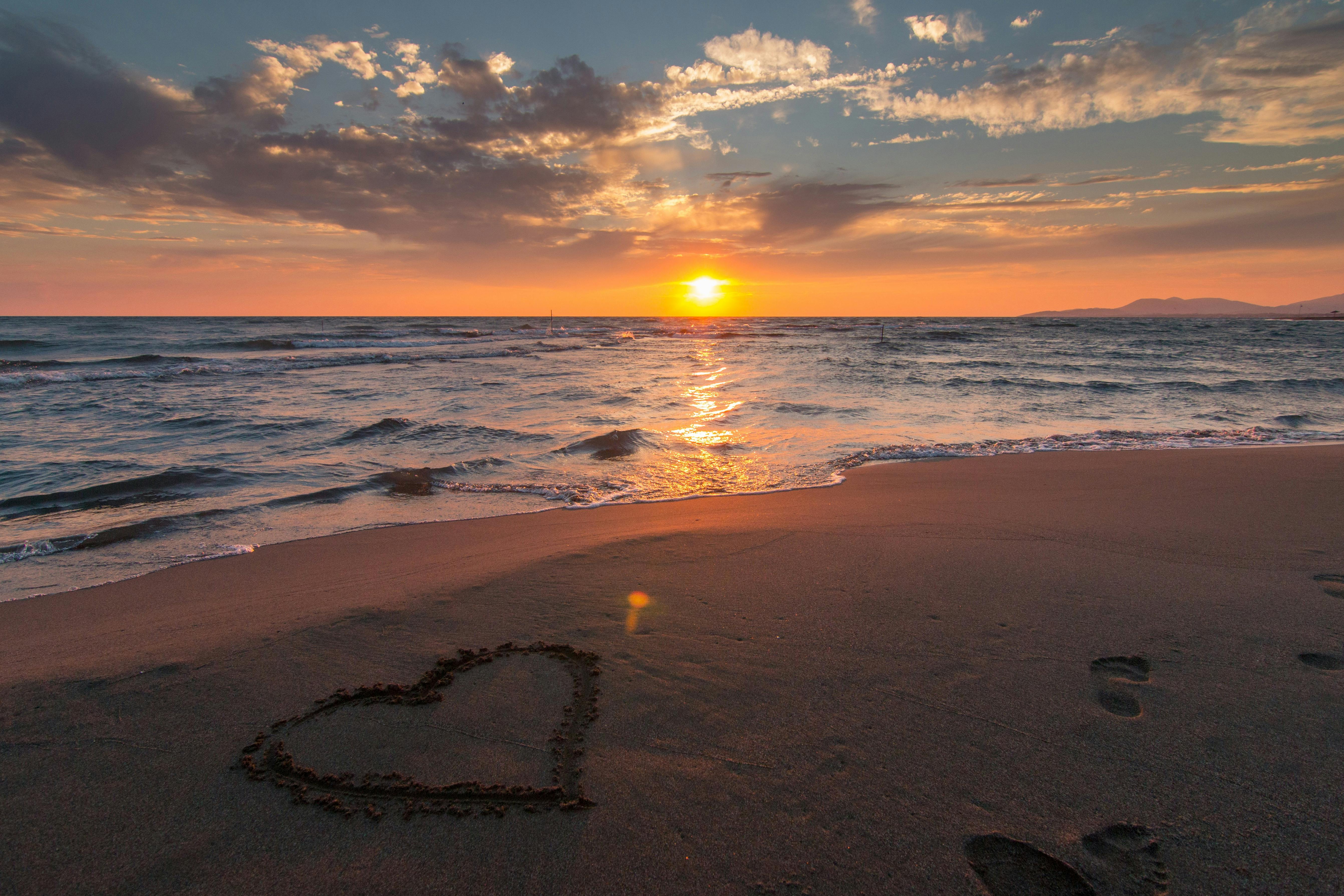 Serene beach at sunset with soft waves and a warm glow, symbolizing peace and remembrance.
